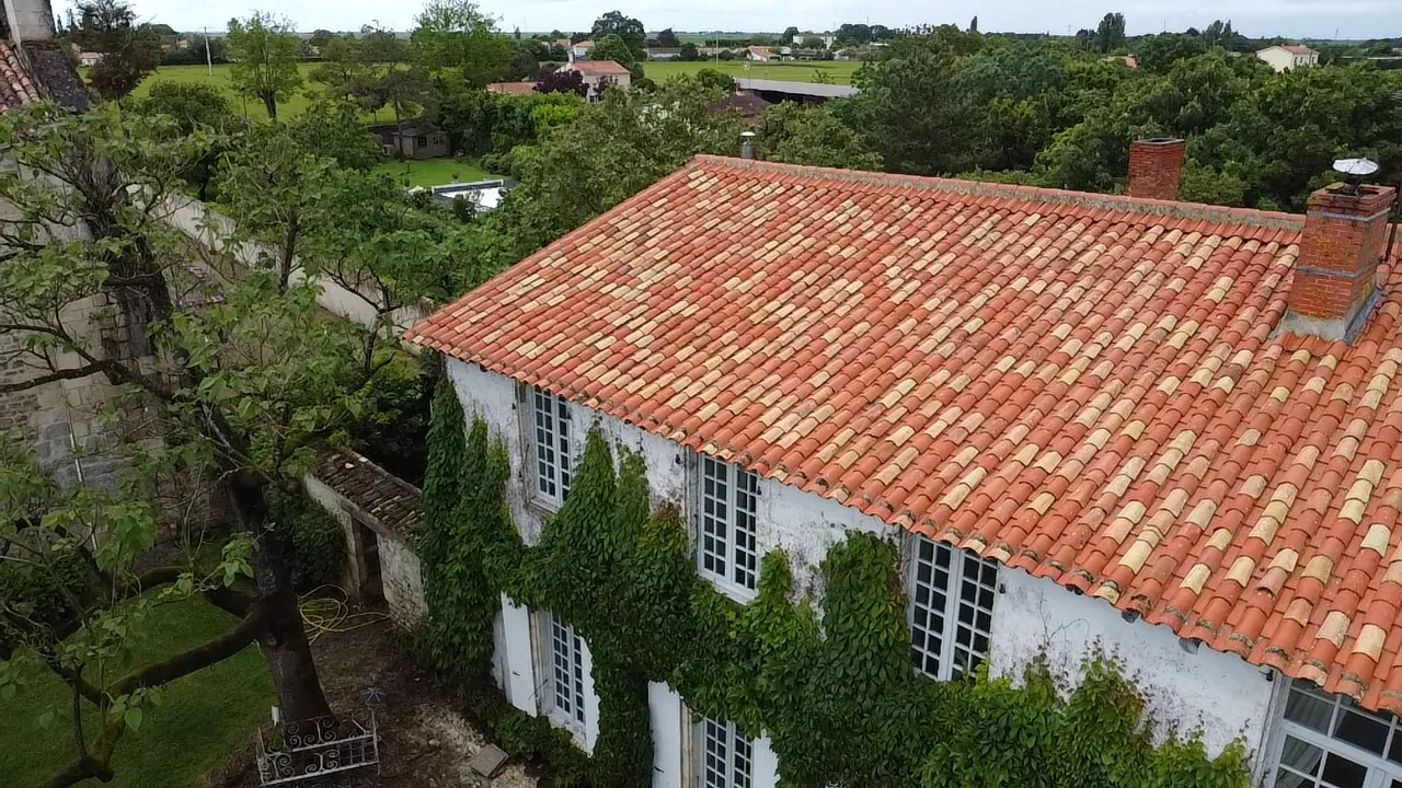Vue d’ensemble d’une maison avec toiture en tuiles et façade claire