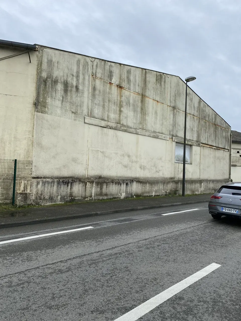 Façade industrielle avant le nettoyage, marquée par des traces et des salissures